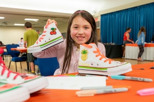 April North poses with her customized shoes during Operation Sole at JBSA-Fort Sam Houston, Texas, June 14.