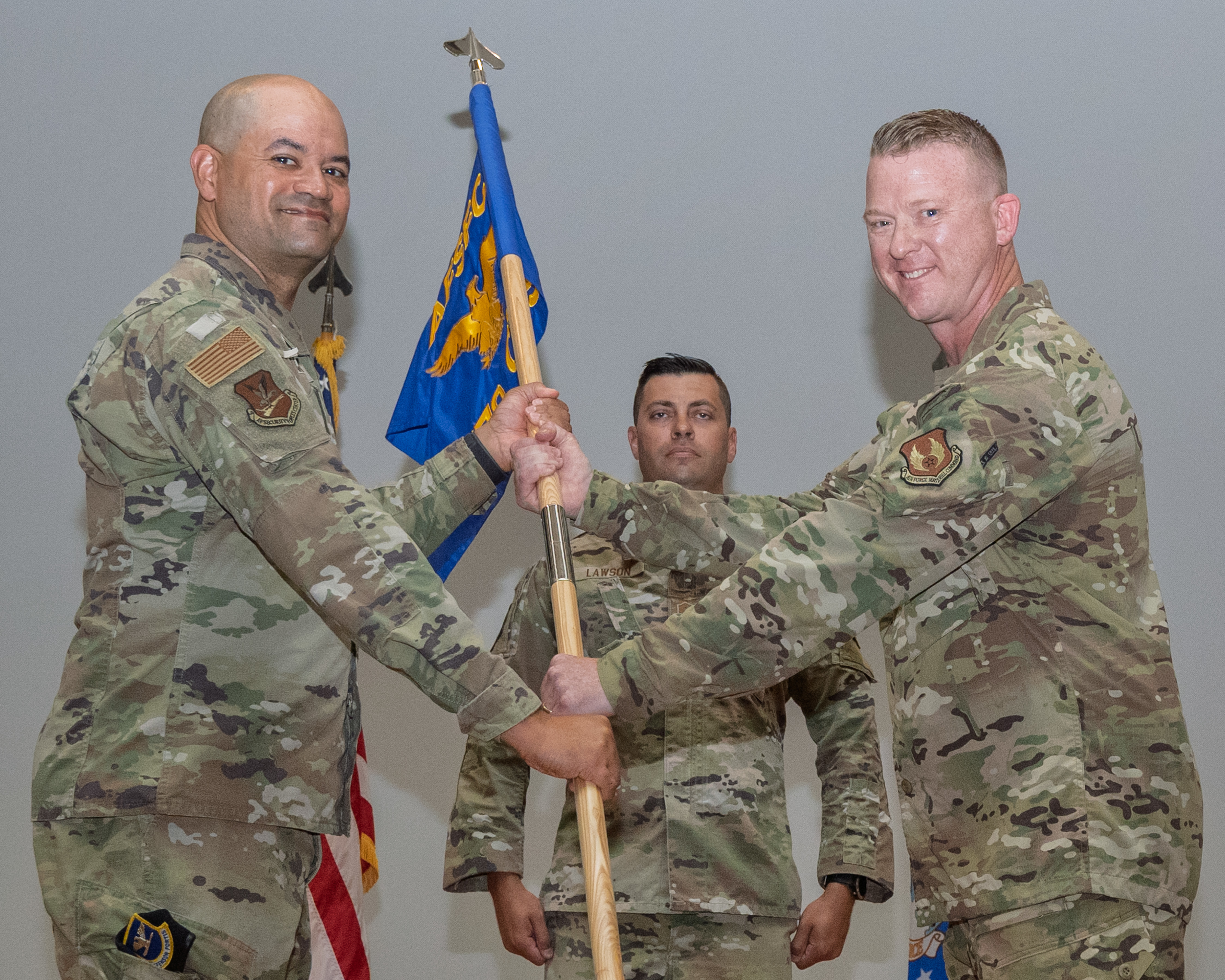 Col. Scott Haselden, right, hands the 570th Combat Training Squadron guidon to Col. Jason Harris, Air Force Security Forces Center commander, during a change of command ceremony at Fort Bliss, Texas, June 27, 2025. The 570th CTS was activated in 2024, with Haselden overseeing more than 180 detachment personnel transition to squadron status. (U.S. Air Force photo by Senior Airman Bob Teichmann)
