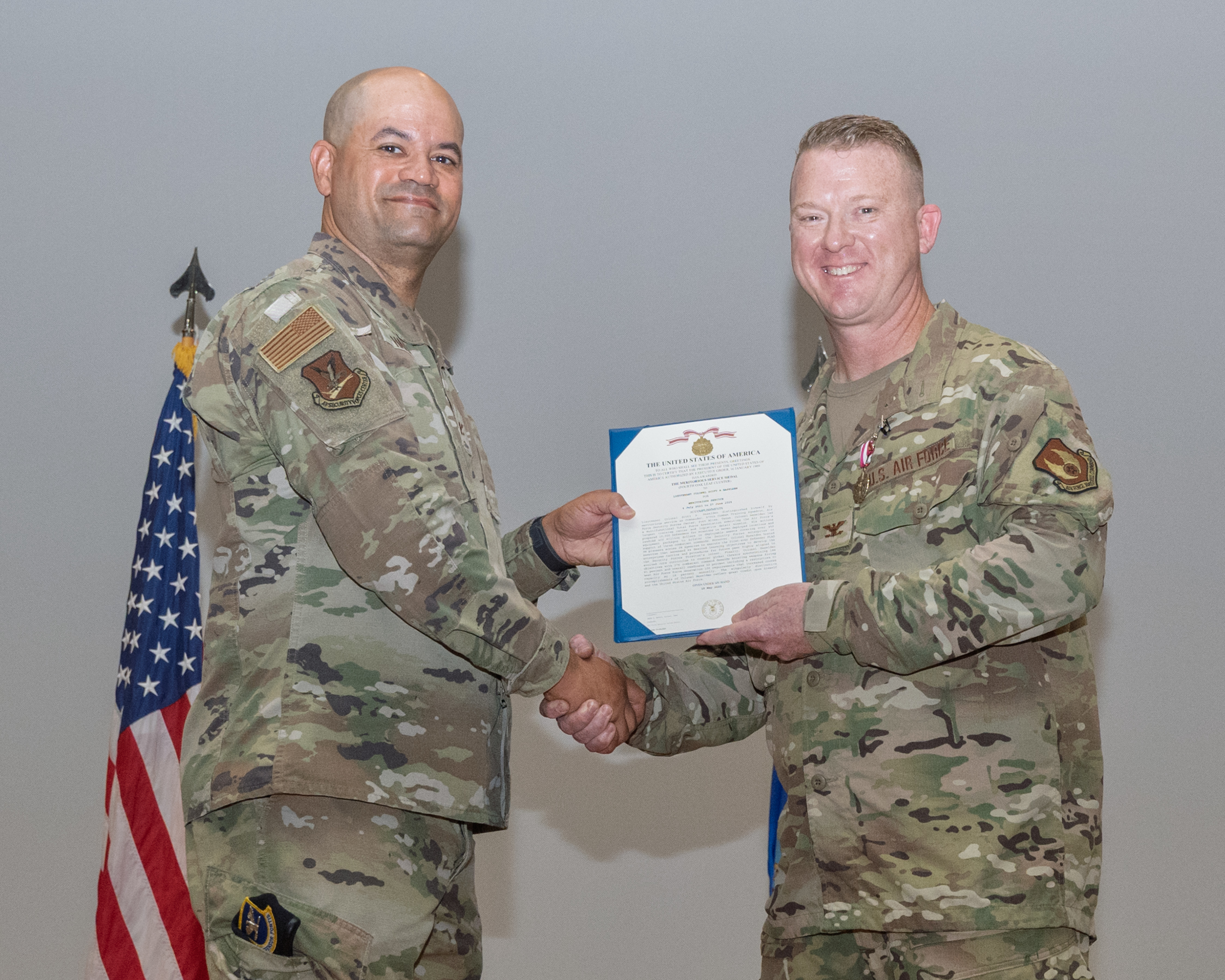 Col. Scott Haselden, 570th Combat Training Squadron commander, right, accepts the Meritorious Service Medal from Col. Jason Harris, Air Force Security Forces Center commander, during a change of command ceremony at Fort Bliss, Texas, June 27, 2025. Haselden was commended for overseeing the inaugural Defender Flag, a mission-profile field exercise consisting of security forces teams from every Air Force major command. (U.S. Air Force photo by Senior Airman Bob Teichmann)