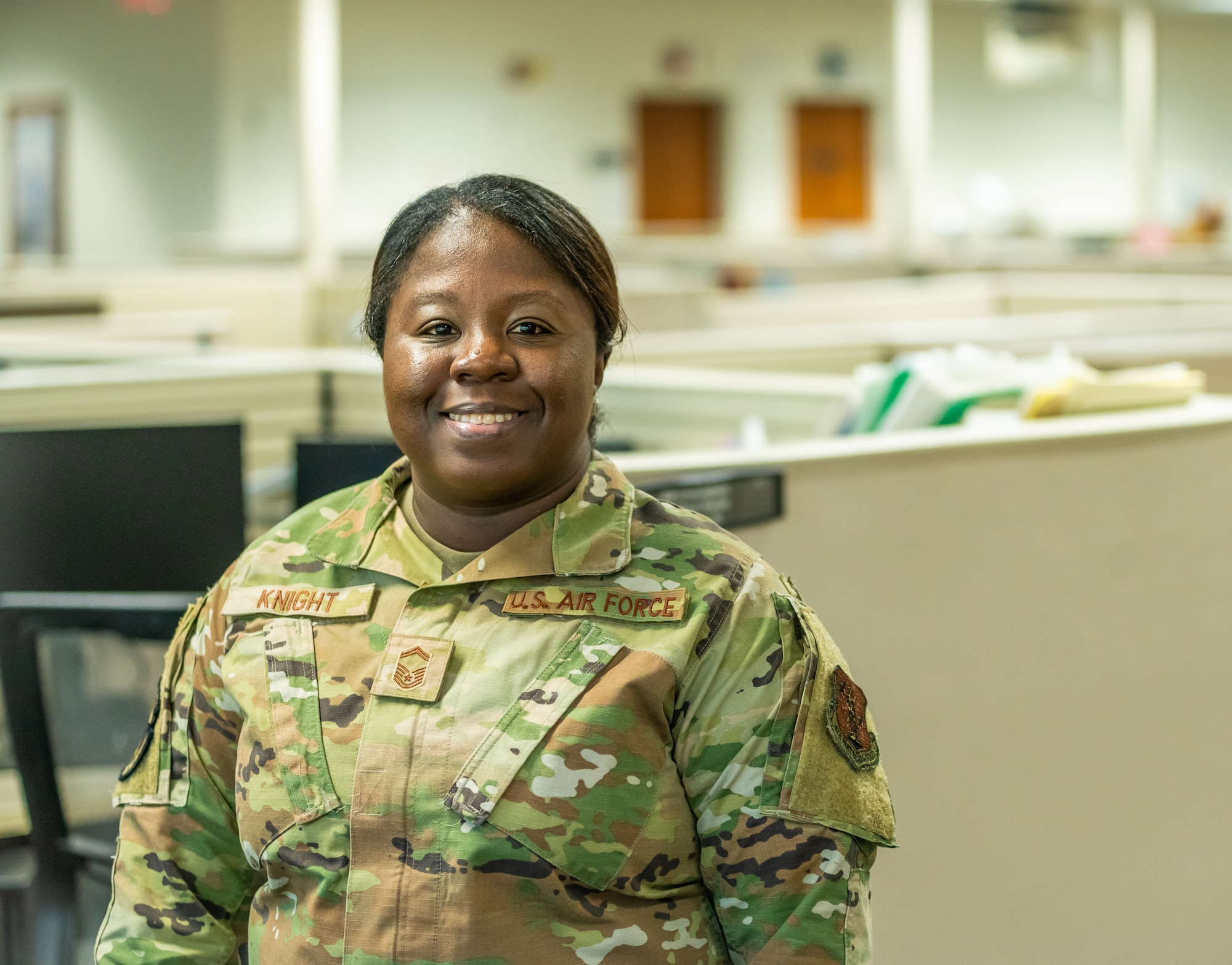 Airman stands in front cubicles