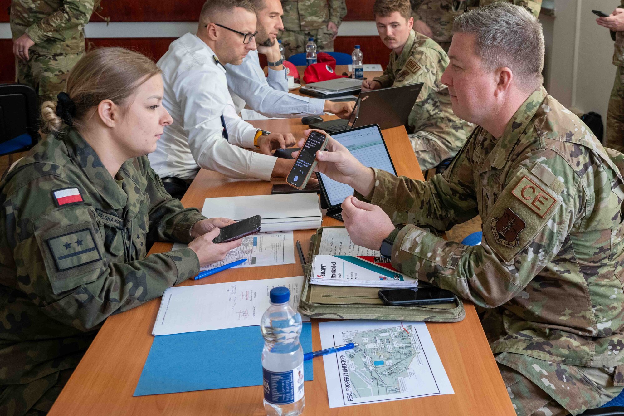 An airman shows the Polish translation on his phone to a polish solider