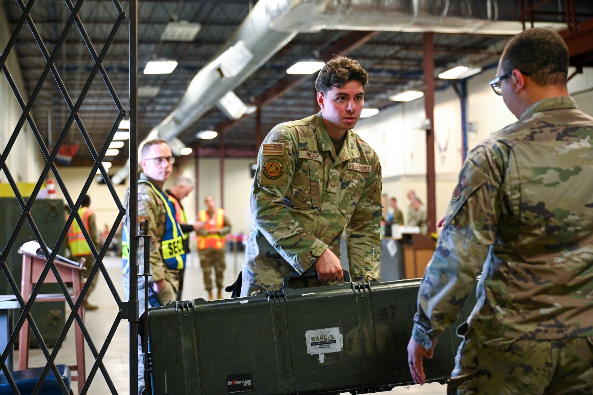 U.S. Air Force Airman 1st Class Juan Pasceri, 97th Logistic Readiness Squadron Aerial Operations Flight unilateral aircrew training element rigger, holds military gear at Altus Air Force Base, Oklahoma, June 5, 2025. Members of the Aerial Operations Flight participated in this mass deployment exercise, held as part of the Combat Readiness Inspection. (U.S. Air Force photo by Airman 1st Class Lauren Torres)