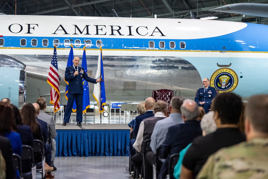 Two gentlemen in service dress uniforms are on stage in front of a crowd