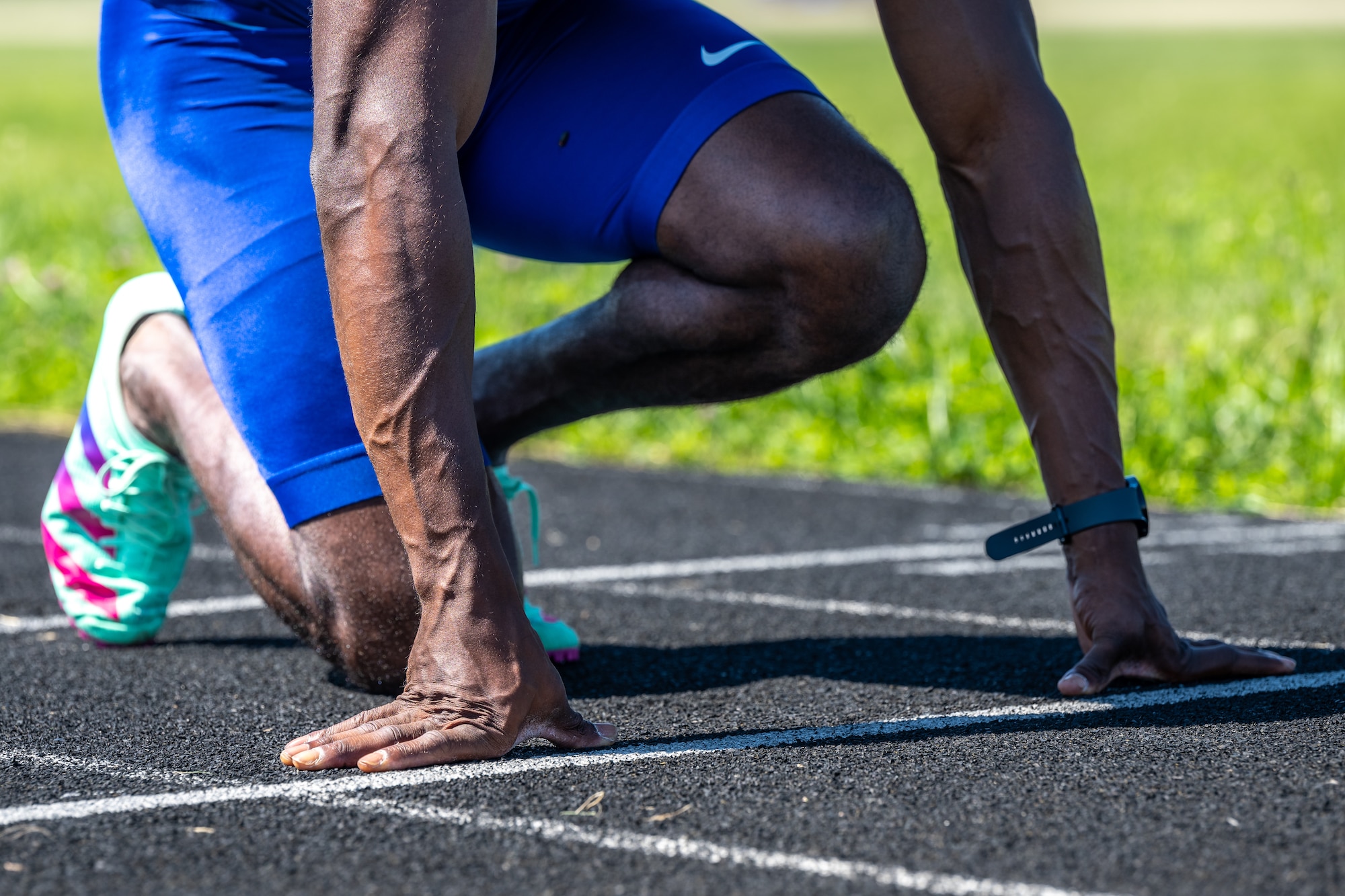 A close-up of Capt. Banks hands and feet as he crouches on the track