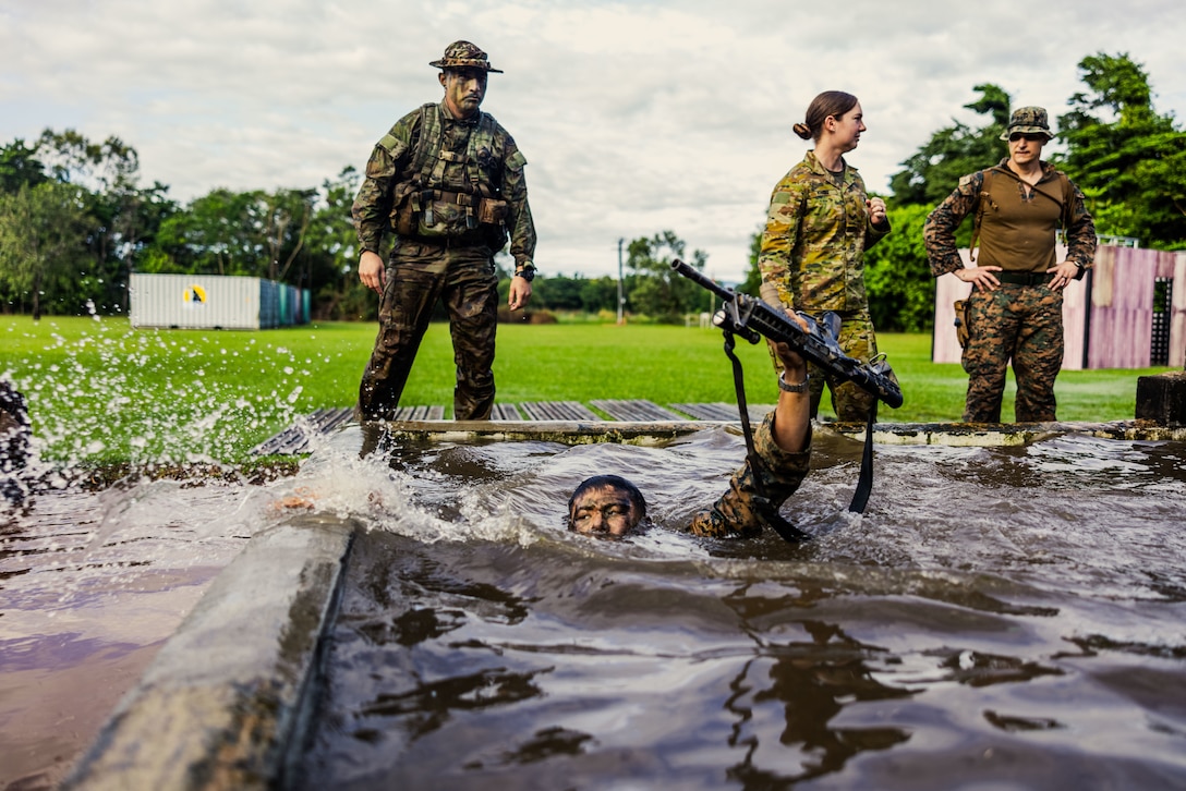 U.S. Marine Corps 1st Lt. Arron Ku, a field artillery officer with Kilo Battery, 3rd Battalion, 11th Marine Regiment, Marine Rotational Force – Darwin 25.3, swims and holds his M4 carbine above water as part of True Grit during jungle warfare training at the Combat Training Centre in Tully, Australia, June 26, 2025.