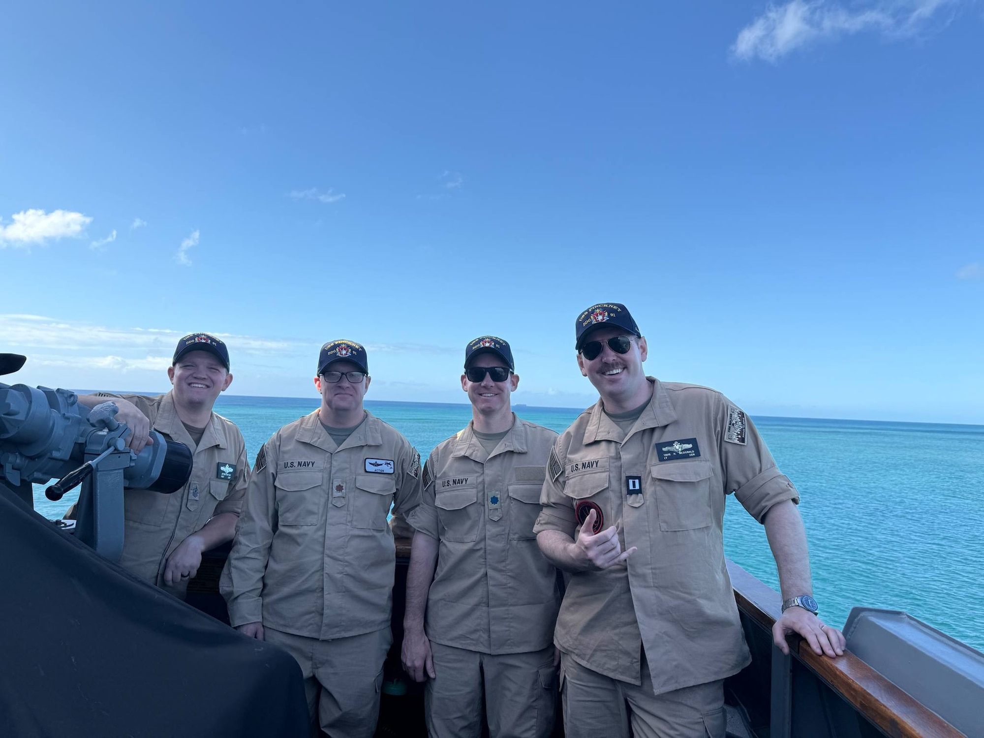 Four men in military uniforms on a ship