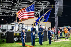 Senior Airman Frances Sampang, 412th Medical Group, sings the national anthem while the Desert Junior-Senior High School honor guard team render proper flag courtesies at Summer Bash on Edwards Air Force Base, July 4. (Air Force photo by Giancarlo Casem)