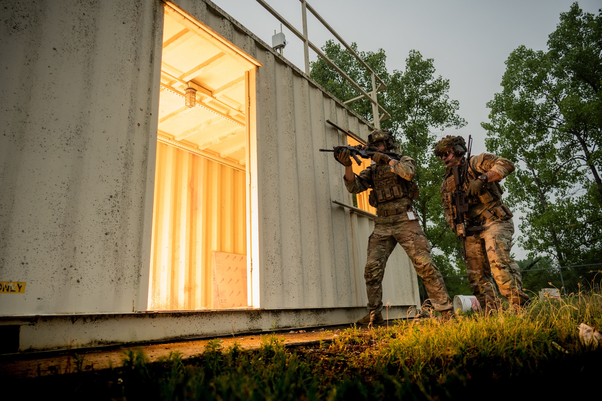 Airmen wait to enter a room after a flash bang explodes