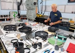 Neil Patterson, Senior Underwater Breathing Apparatus (UBA) technician, performs an entire overhaul of a MK16 Mod 1 UBA during a 72-month routine maintenance cycle, May 28. The unit is completely disassembled and subjected to specialized oxygen cleaning procedures to ensure optimal warfighter support. *Background boards were altered to safeguard mission information. (U.S. Navy photo by Ronnie Newsome)