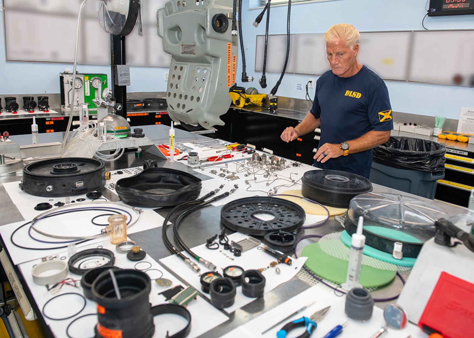 Neil Patterson, Senior Underwater Breathing Apparatus (UBA) technician, performs an entire overhaul of a MK16 Mod 1 UBA during a 72-month routine maintenance cycle, May 28. The unit is completely disassembled and subjected to specialized oxygen cleaning procedures to ensure optimal warfighter support. *Background boards were altered to safeguard mission information. (U.S. Navy photo by Ronnie Newsome)