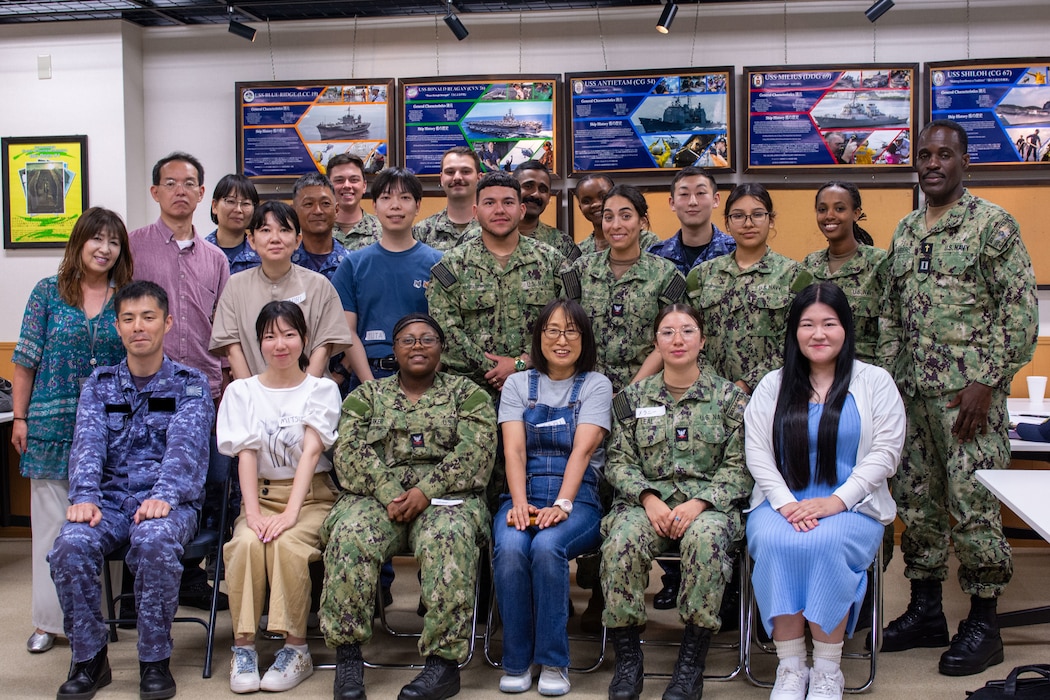 Sailors, Japanese nationals and Japan Maritime Self-Defense Force members pose for a group photo during the Navy Awesome Cafe.