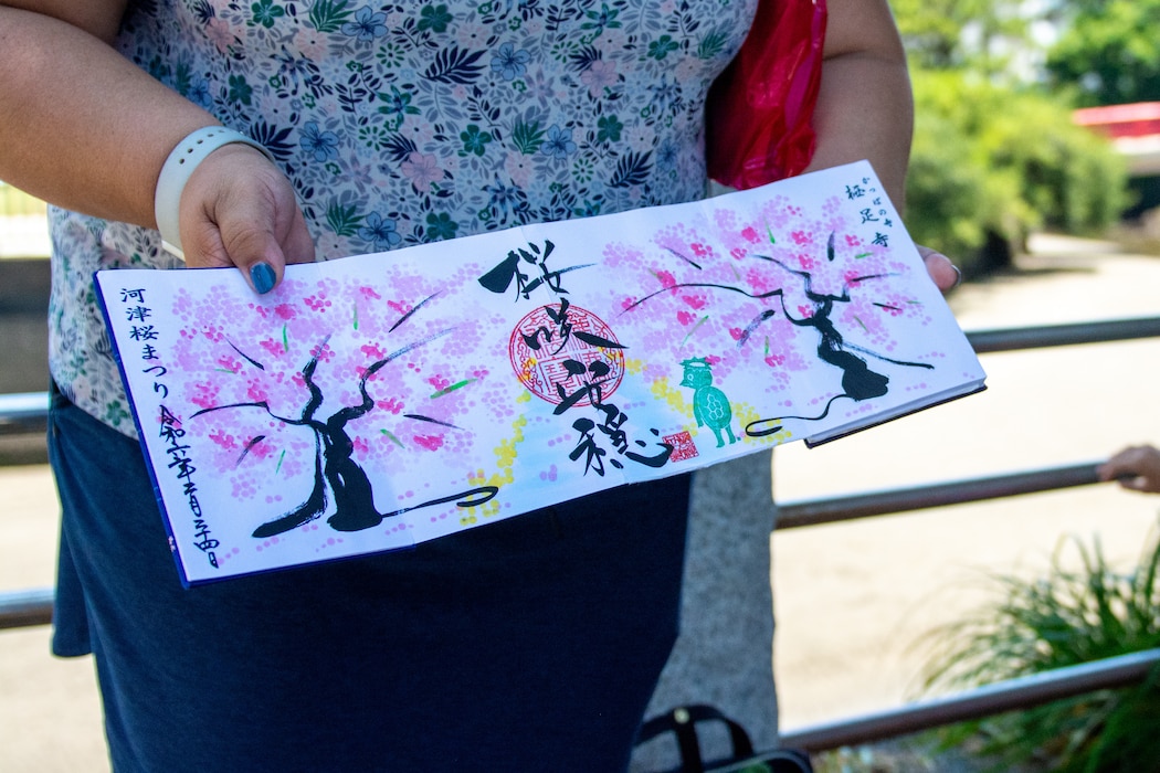 Darlene Hernandez-Purvis, a volunteer for the Commander, Fleet Activities Yokosuka Fleet and Family Support Center (CFAY FFSC) shows off her impressive collection of Goshuin stamps during the Zushi-Hayama Tour Friday, June 27, 2025.