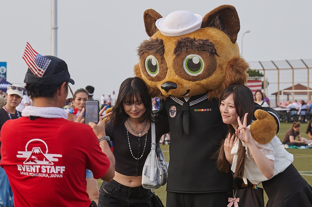 Two girls pose with Yoko-Pon at the CFAY MWR Holds 4th of July Celebration