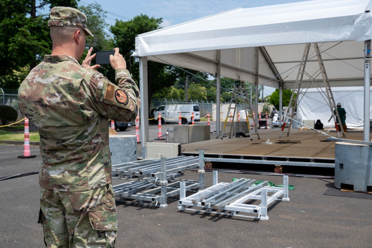 A U.S. Air Force member takes a photo of equipment and a tent set up.