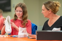 Gretchen Betten (right) and her daughter, Bethany, customize a pair of shoes during Operation Sole, at JBSA-Fort Sam Houston, Texas, June 14.