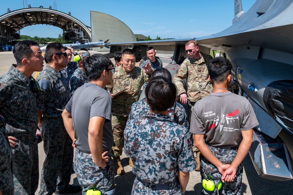 U.S. Air Force Senior Airman Tadayoshi Kiriyama, center, 35th Maintenance Squadron, aerospace ground equipment journeyman, briefs Japan Air Self-Defense Force members on U.S. Air Force F-16 Fighting Falcon refueling procedures ahead of exercise Resolute Force Pacific 2025 at Misawa Air Base, Japan, July 8, 2025. Training with allies improves the bilateral mission goals of the exercise, ensuring a rapid and effective combined response to any threat in the Indo-Pacific region. (U.S. Air Force photo by Senior Airman Brittany Russell)