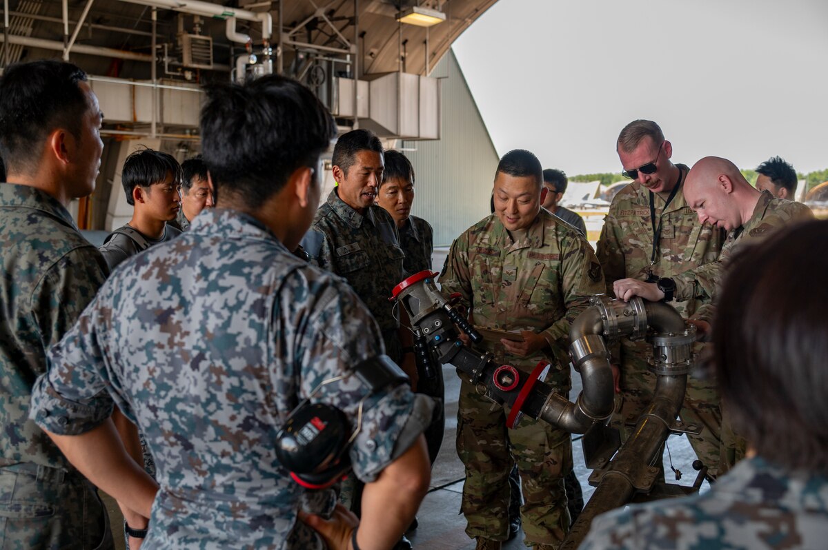 U.S. Air Force Senior Airman Tadayoshi Kiriyama, center, 35th Maintenance Squadron, aerospace ground equipment specialist, showcases a pantograph to Japan Air Self-Defense Force members ahead of exercise Resolute Force Pacific (REFORPAC) 2025 at Misawa Air Base, Japan, July 8, 2025. REFORPAC 2025, the largest contingency response exercise ever conducted by the USAF in the Pacific, demonstrates how working alongside allies and partners enhances our ability to respond effectively to challenges in the Indo-Pacific region. (U.S. Air Force photo by Senior Airman Brittany Russell)