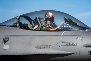 U.S. Air Force Col. Matthew Kenkel, 35th Fighter Wing deputy commander, touches an American flag after his final, or fini, flight in a U.S. Air Force F-16 Fighting Falcon.