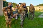 From left, U.S. Air Force Senior Airmen Matthew Yu and Josh Miller, assigned to 146 Airlift Wing and 123rd Airlift Wing, practice stretcher carrying during an emergency management battlefield expeditionary response deployment for training at McCrady Training Center, Eastover, South Carolina, June 26, 2025. Yu and Miller participated in Fox EMBER to home in on their skills for mission readiness.