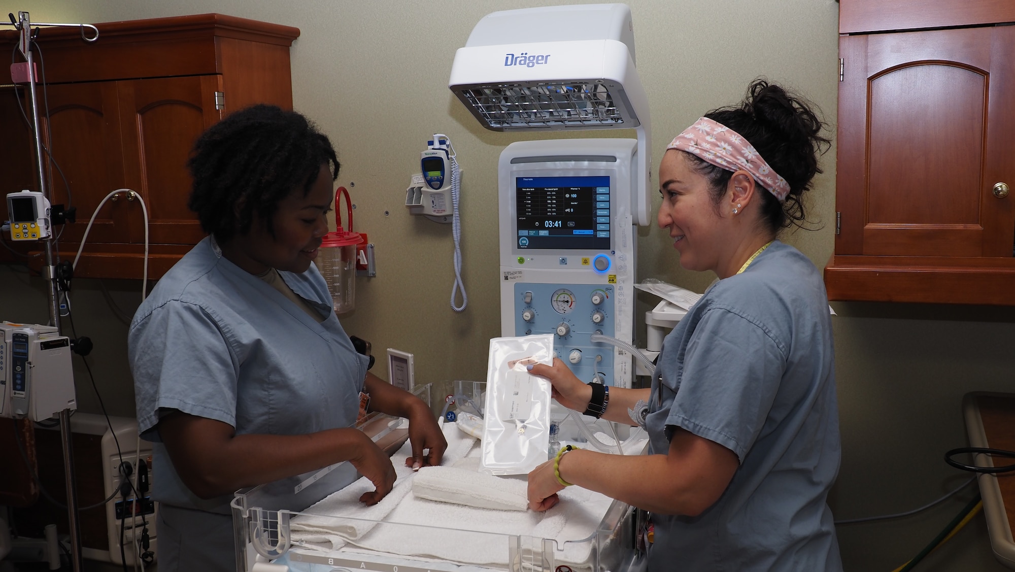 Gabrielle Quintero, a registered nurse in the EACH Inpatient Ward, provides training on an infant warmer to Senior Airman Antonia Jackson, an aerospace medical technician from the 910th Medical Squadron from Youngstown Air Reserve Station, Ohio.
