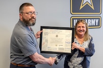Waylon Vinson, U.S. Army Financial Management Command human resources specialist, presents Melissa L. Ooten, USAFMCOM assistant chief of staff (G1), with a certificate of retirement at the Maj. Gen. Emmett J. Bean Federal Center in Indianapolis March 13, 2025. Ooten retired after more than 35 years of federal civil service. (U.S. Army photo by Mark R. W. Orders-Woempner)