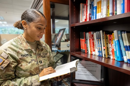 Capt. Jasmine Thompson, U.S. Army Financial Management Command aide de camp, reads a book at a new leadership library opened by USAFMCOM at the Maj. Gen. Emmett J. Bean Federal Center in Indianapolis July 7, 2025. The library was the brainchild of Kimberly Hood, USAFMCOM deputy chief of staff, meant to provide leadership resources for USAFMCOM military and civilian personnel. (U.S. Army photo by Mark R. W. Orders-Woempner)