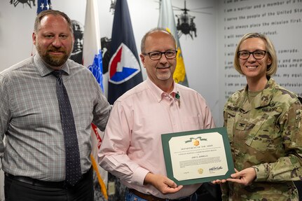 Col. Michelle M. Williams, U.S. Army Financial Management Command commander, right, and Ryan Busby, USAFMCOM deputy to the commander, left, present Joby Jerrells, USAFMCOM senior attorney advisor, with a Department of the Army civilian service commendation medal at the Maj. Gen. Emmett J. Bean Federal Center in Indianapolis May 2, 2025. The award recognized Jerrell's service as the command's senior attorney advisor from October 2016 to May 2025. (U.S. Army photo by Mark R. W. Orders-Woempner)