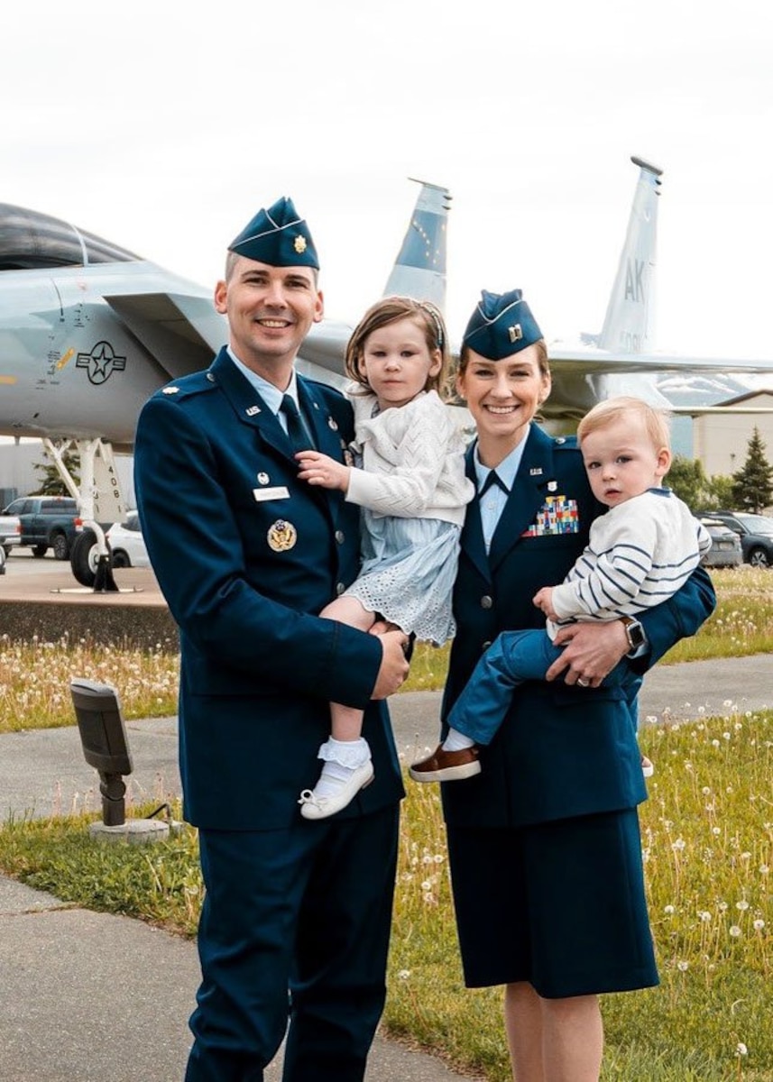 Photo of U.S. Air Force Maj. Ryan VanArtsdalen, Air Command and Staff College fellow, and Capt. Melissa VanArtsdalen, Squadron Officer School instructor, pose for a photo with their two children during a change of command ceremony at Joint Base Elemendorf-Richardson, Alaska,