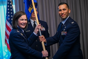 U.S. Air Force Col. Michael S. Luna, right, new commander of the Bolling Medical Squadron at Joint Base Anacostia-Bolling, receives the unit guidon from U.S. Air Force Col. Stacy Friesen, commander of the Andrews Medical Group at Joint Base Andrews, during the Bolling Medical Squadron assumption of command ceremony at JBAB, Washington, D.C., July 8, 2025. Luna previously commanded the 75th Healthcare Operations Squadron at Hill Air Force Base, Utah. (U.S. Air Force photo by Airman 1st Class Shanel Toussaint)