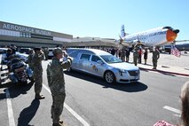 Airmen lining a road salute a hearse carrying the remains of Lt. Wilson.