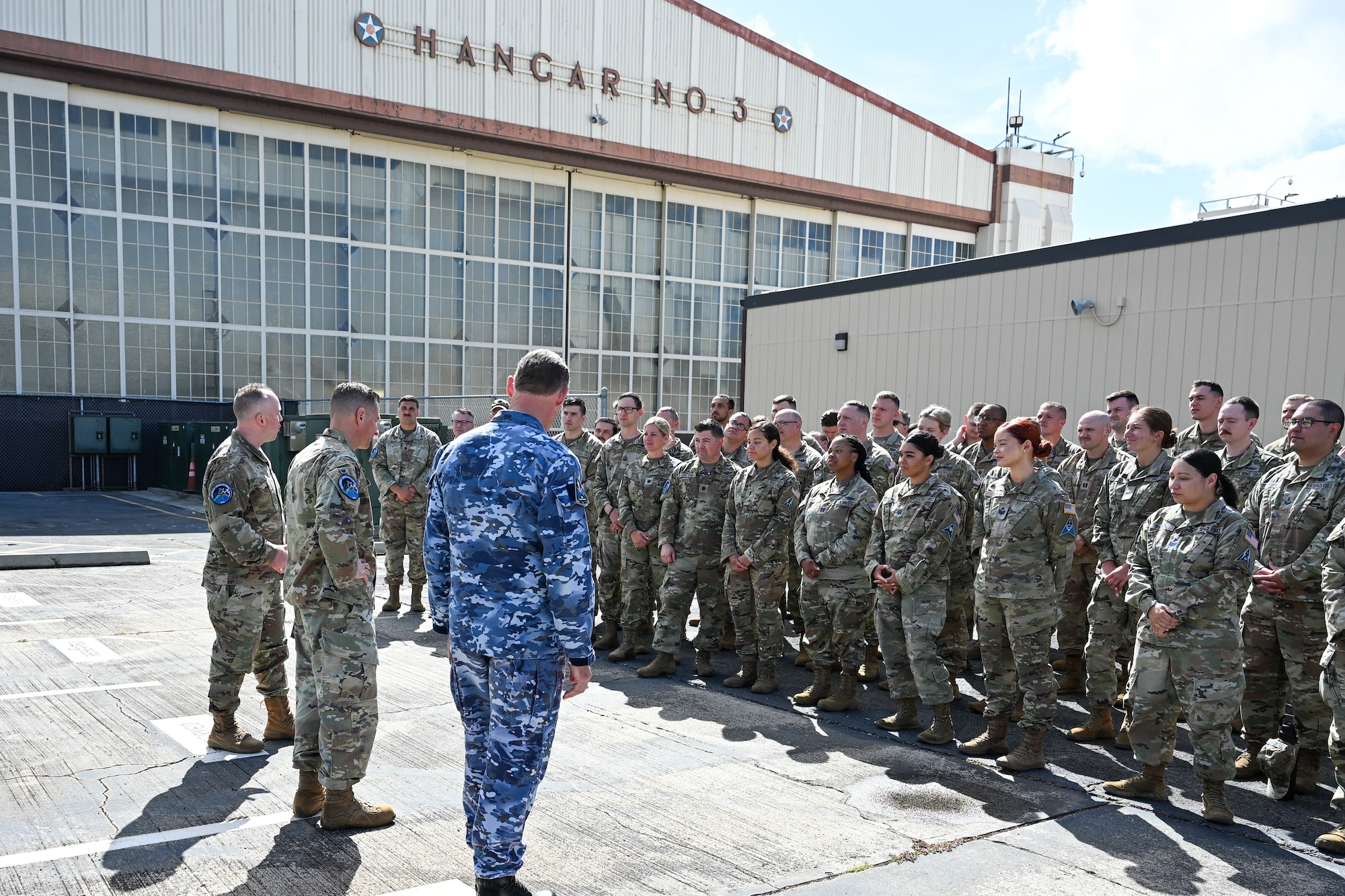Three military officials address a group of Guardians and civilians. From left to right: U.S. Space Force Lt. Col. Shawn Green, Col. Jay Steingold (Resolute Space 2025 exercise director), and Royal Australian Air Force Group Captain Darrell May (Space Forces Indo-Pacific deputy commander).