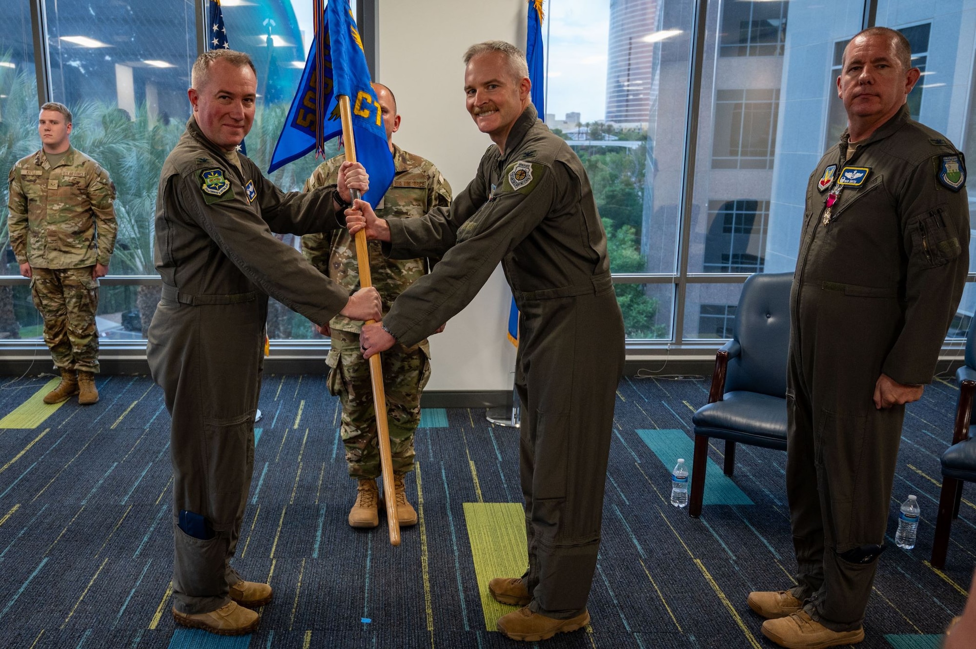 photo of US Airmen holding a unit flag in between them