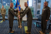 photo of US Airmen holding a unit flag in between them