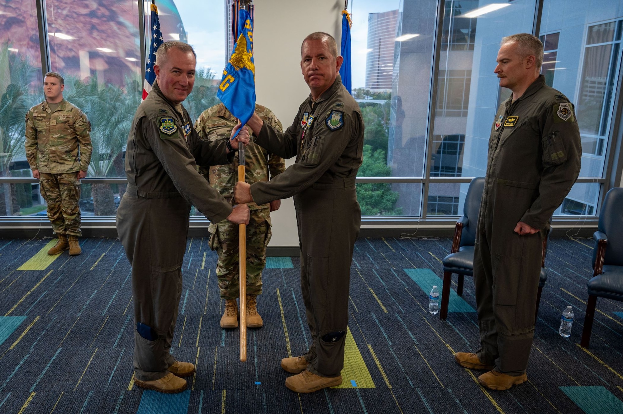 photo of US Airmen holding a unit flag in between them