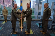 photo of US Airmen holding a unit flag in between them