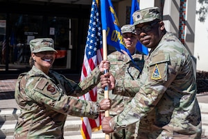 U.S. Air Force Col. Joi Dozier, 30th Medical Group commander, receives the guidon from U.S. Air Force Lt. Col. Marcus Boone, outgoing 30th Operational Medical Readiness Squadron commander, during the 30 OMRS change of command ceremony at Vandenberg Space Force Base, Calif., July 8, 2025. Boone relinquished command to U.S. Air Force Major Michael Estacion.