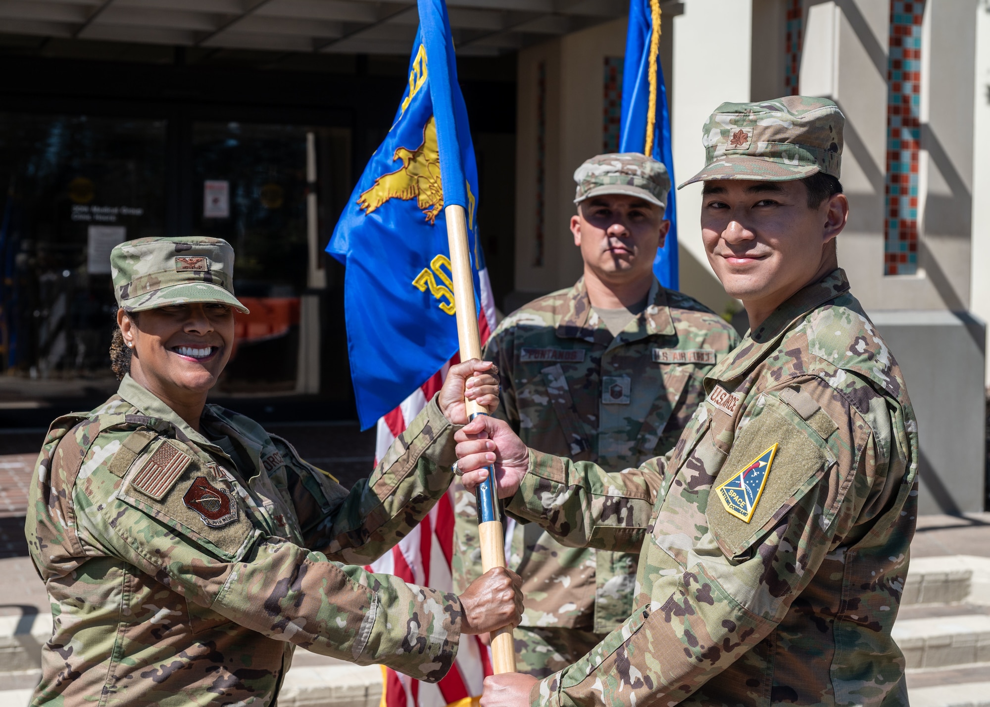 U.S. Air Force Major Michael Estacion, incoming 30th Operational Medical Readiness Squadron commander, receives the30 OMRS guidon from U.S. Air Force Col. Joi Dozier, 30th Medical Group commander, during the 30 OMRS change of command ceremony at Vandenberg Space Force Base, Calif., July 8, 2025. The passing of the guidon signifies the transfer of command from one member to the next, ringing in a new era at the unit.