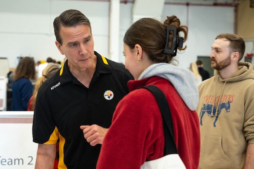 A doctor in civilian clothes questions a patient