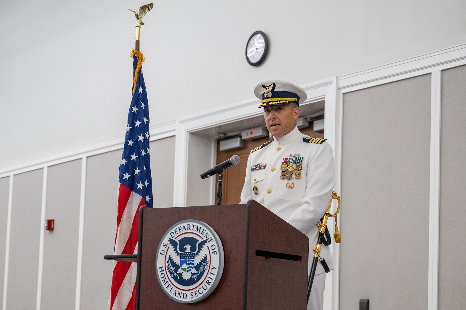 Capt. Jason C. Aleksak delivers remarks after assuming command of Coast Guard Sector Jacksonville during a change of command ceremony at the Jacksonville Public Library in Jacksonville, Florida, July 9, 2025. Rear Adm. Douglas Schofield, commander, Coast Guard Southeast District, presided over the ceremony. (U.S. Coast Guard photo by Petty Officer 3rd Class Kace White)