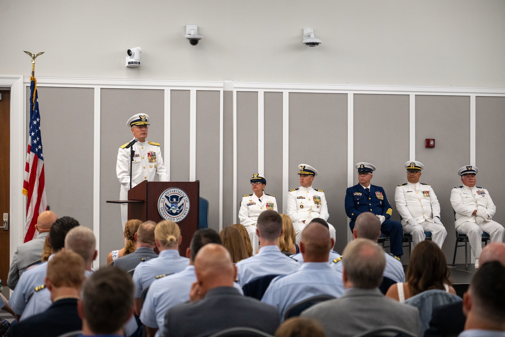 Rear Adm. Douglas Schofield, commander, Coast Guard Southeast District, delivers remarks during Coast Guard Sector Jacksonville’s change of command ceremony at the Jacksonville Public Library in Jacksonville, Florida, July 9, 2025. Schofield presided over the ceremony in which Capt. Janet D. Espino-Young transferred command of Sector Jacksonville to Capt. Jason C. Aleksak. (U.S. Coast Guard photo by Petty Officer 3rd Class Kace White)