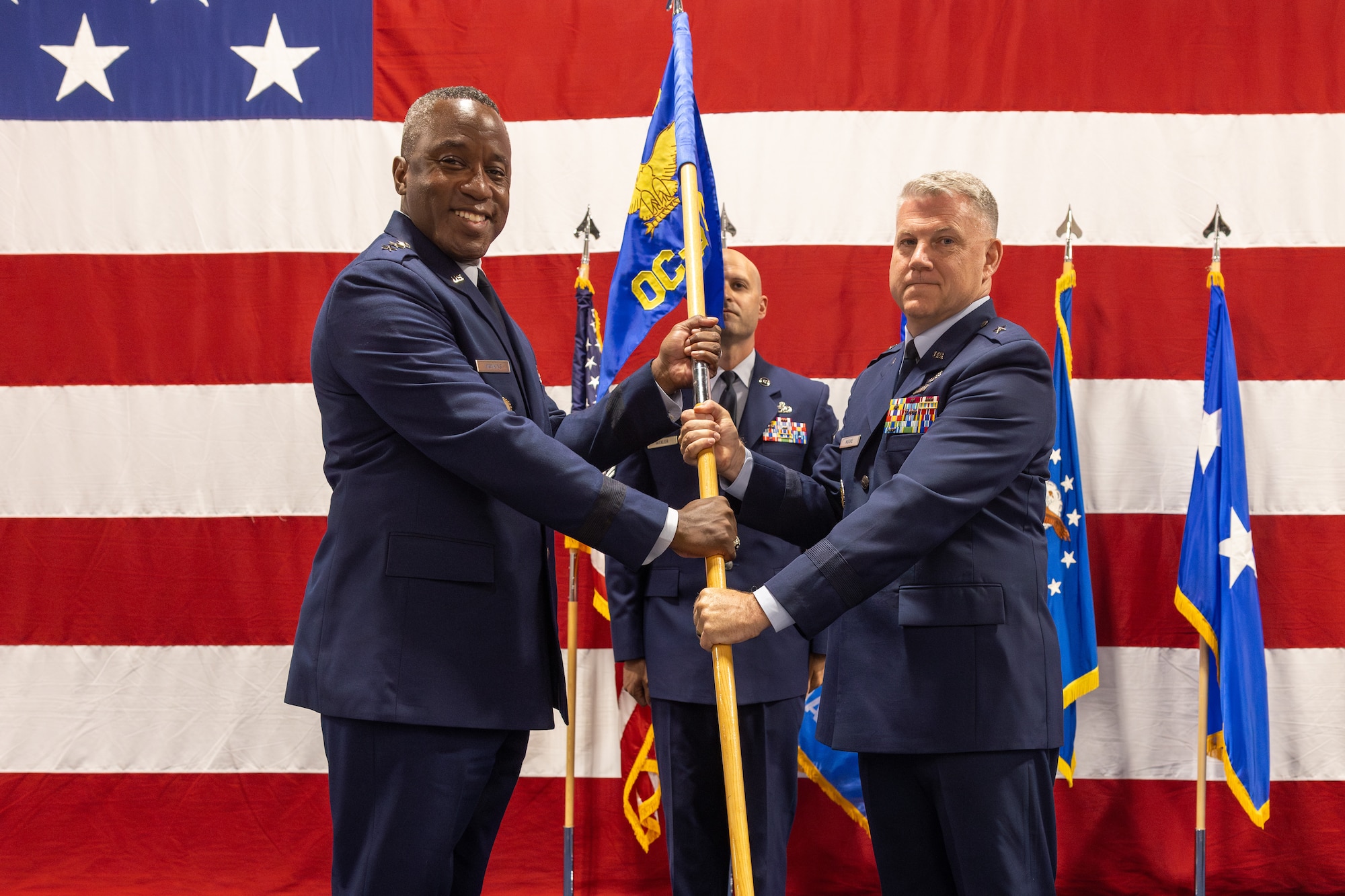 Two men hold flag on stage