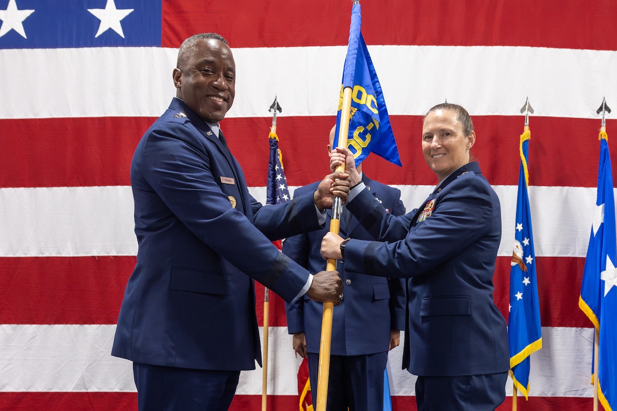 Man and woman hold flag on stage