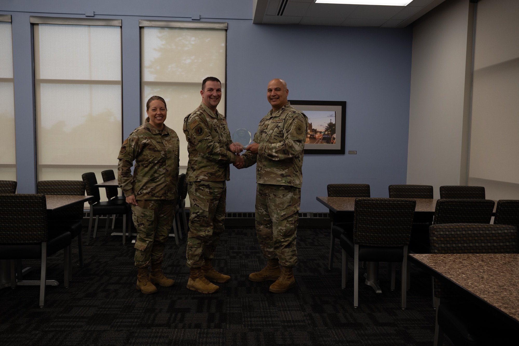 Maj. Robert Semaan holds his quarterly award given to him by Col. Jeffrey Smith and Chief Master Sgt. Andrea Young at Scott Air Force Base, Illinois, June 7, 2025. The winners were selected based on their technical expertise, demonstration of leadership and job performance during the period of January 2025 to March 2025.
