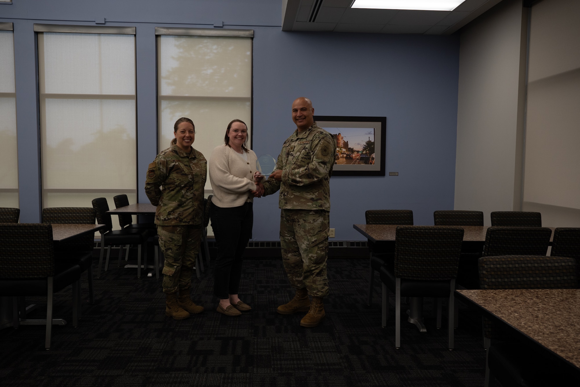 Jessica Callahan holds her quarterly award given to her by Col. Jeffrey Smith and Chief Master Sgt. Andrea Young at Scott Air Force Base, Illinois, June 7, 2025. The winners were selected based on their technical expertise, demonstration of leadership and job performance during the period of January 2025 to March 2025.