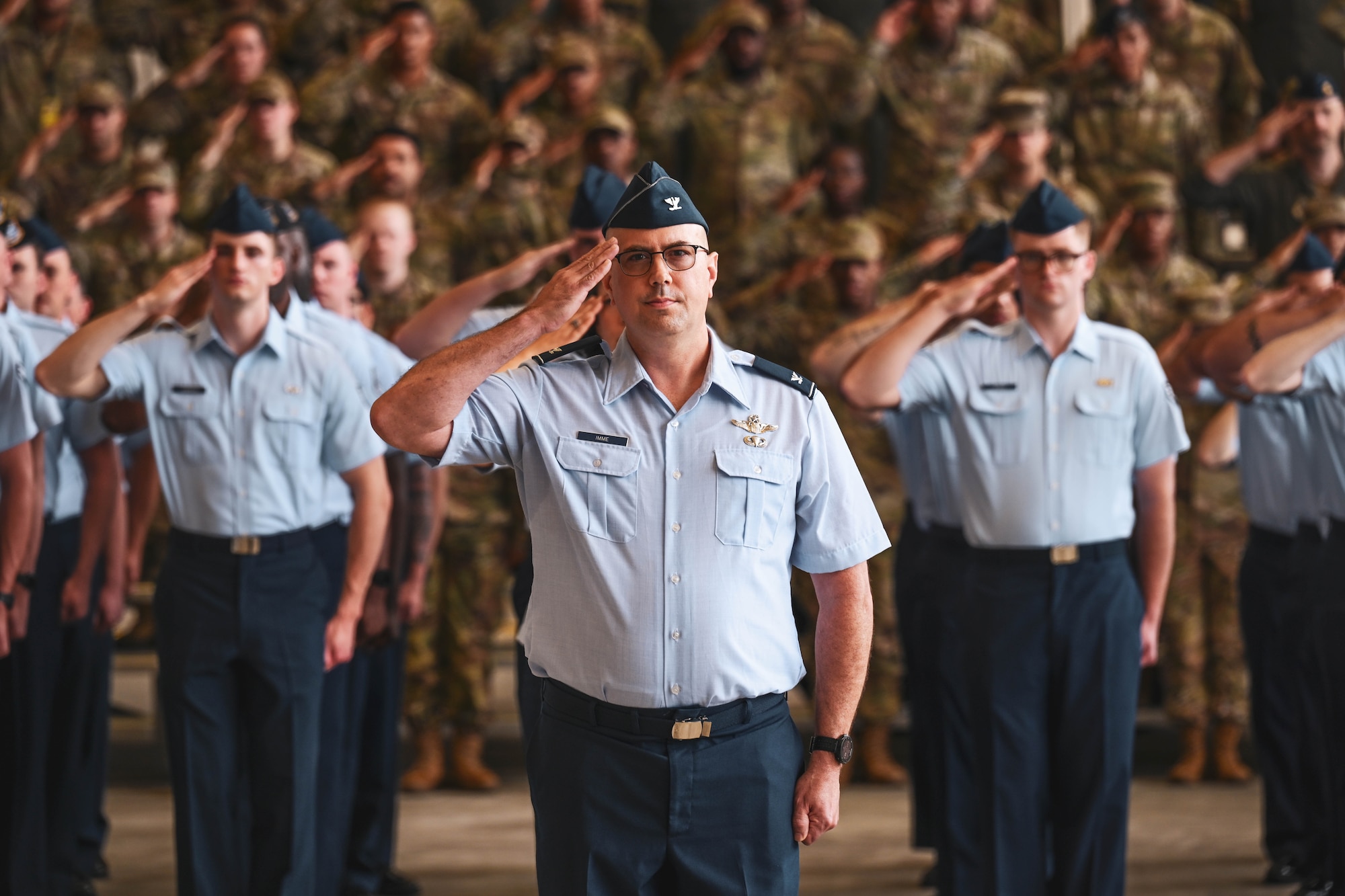 Military members in formation render a salute.