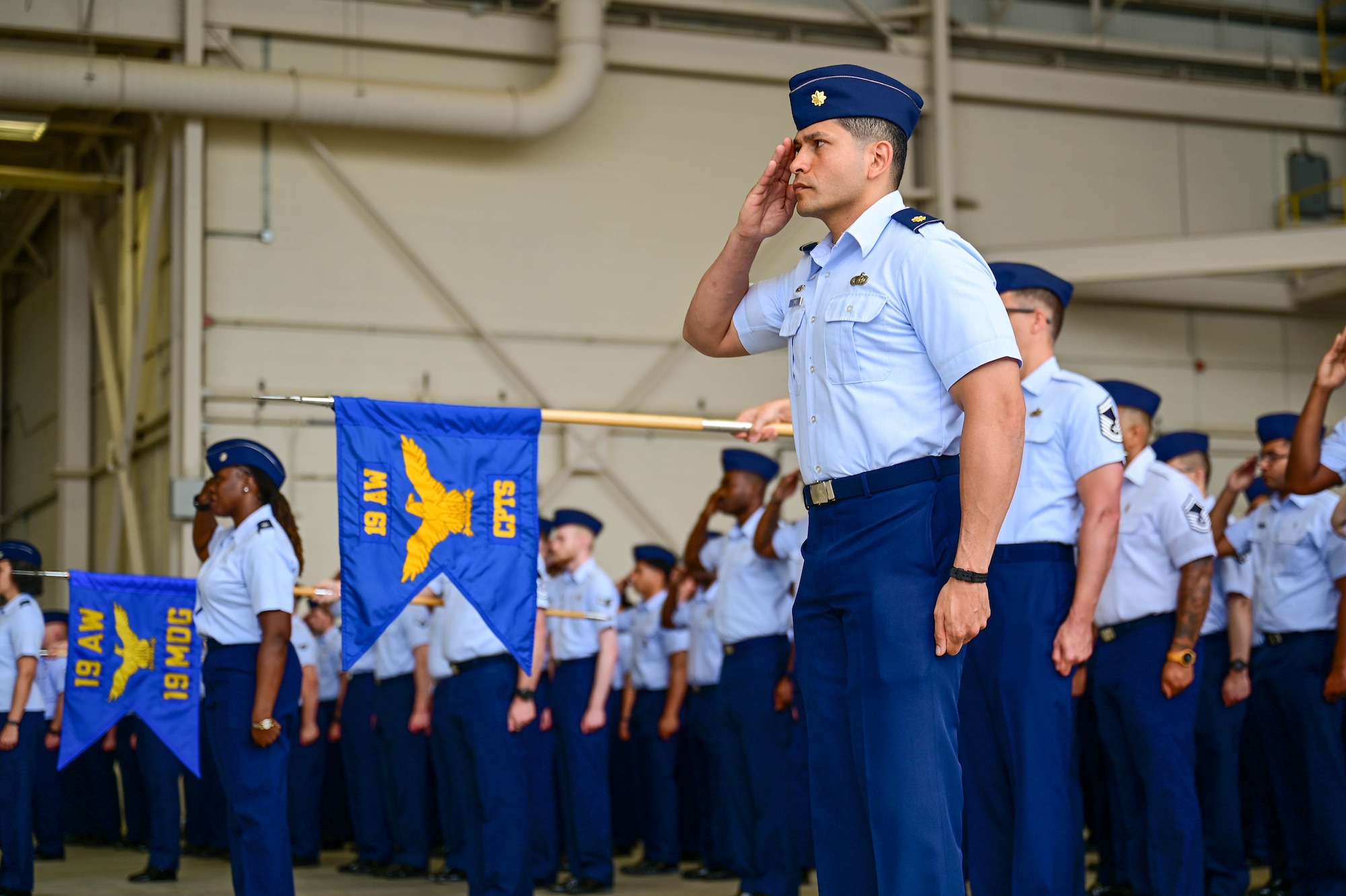 Military members in formation render a salute.