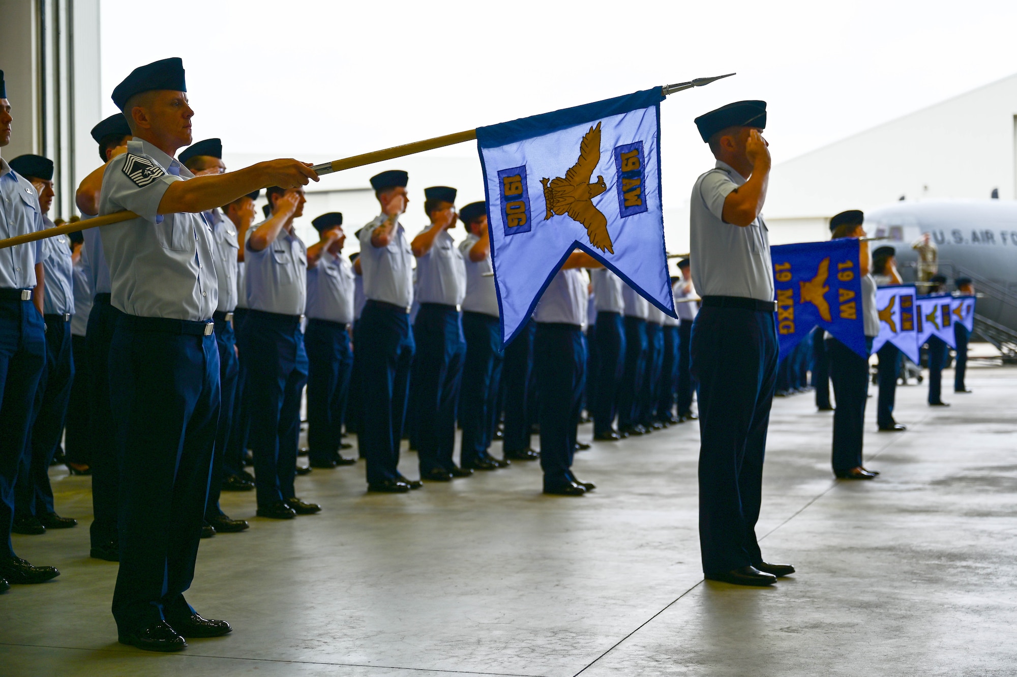 Military members in formation render a salute.