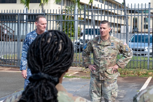  U.S. Space Force Col. Jay Steingold (right) and Royal Australian Air Force Group Captain Darrell May (left) stand outdoors. Col. Steingold has his hands on his hips. They are addressing attendees at the Resolute Space 2025 exercise kickoff near Space Forces Indo-Pacific headquarters in Hawaii.