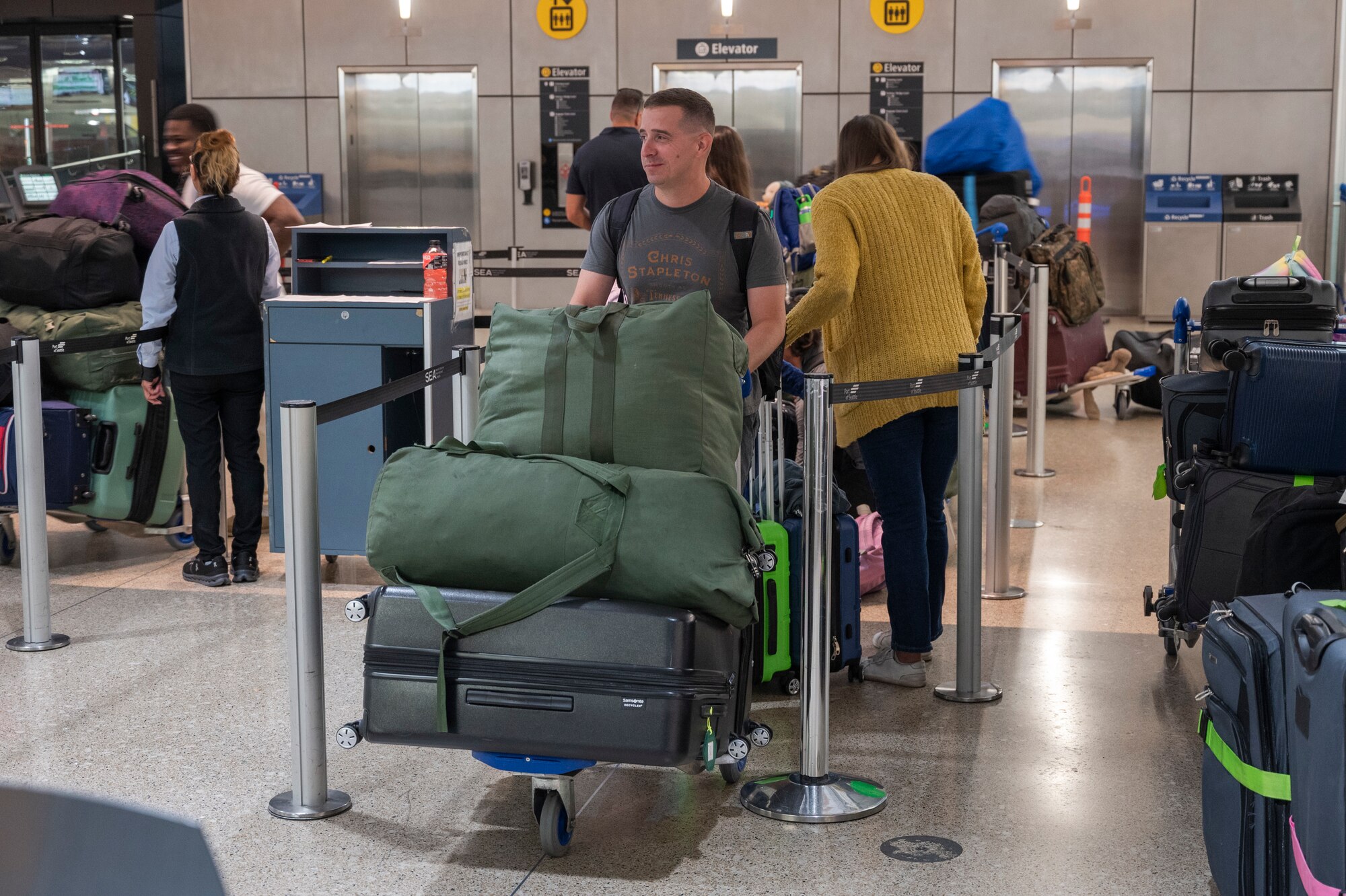 An Air Mobility Command Seattle Gateway passenger stands in the check-in line at the Seattle-Tacoma International Airport, Washington, July 3, 2025.
