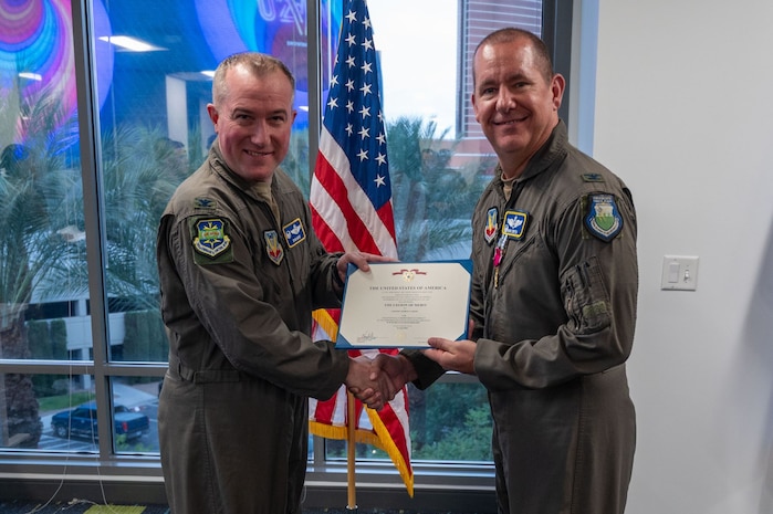 photo of US Airmen holding an award certificate in between them
